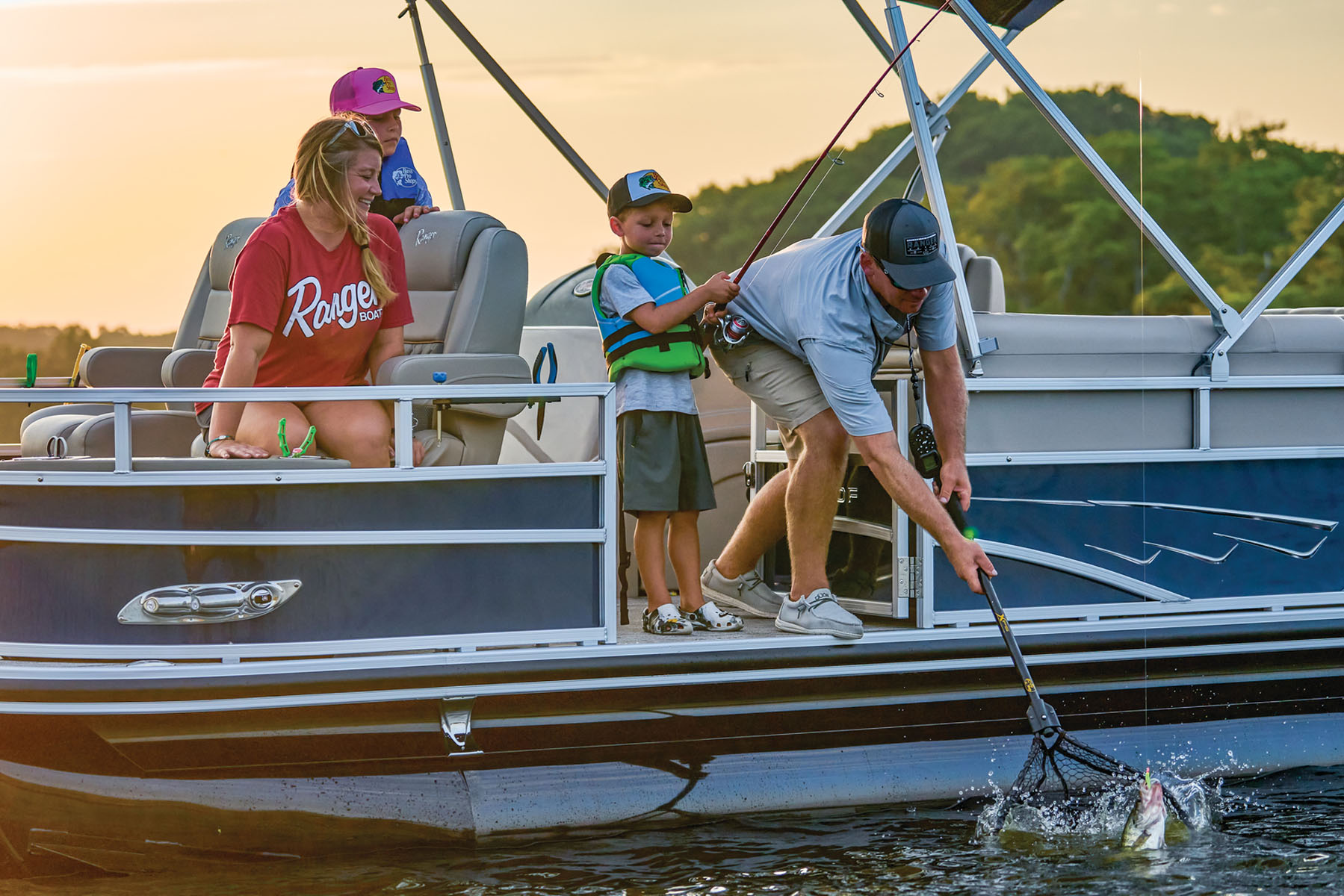 2 kids preparing to fish with help from an adult